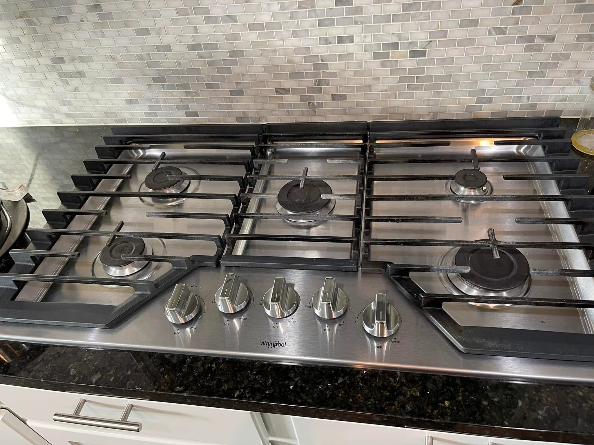 Professionally cleaned stainless steel kitchen cooktop by Greatest Cleaning Services
